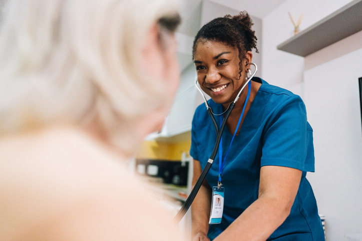 Nurse taking blood pressure of a patient at home.