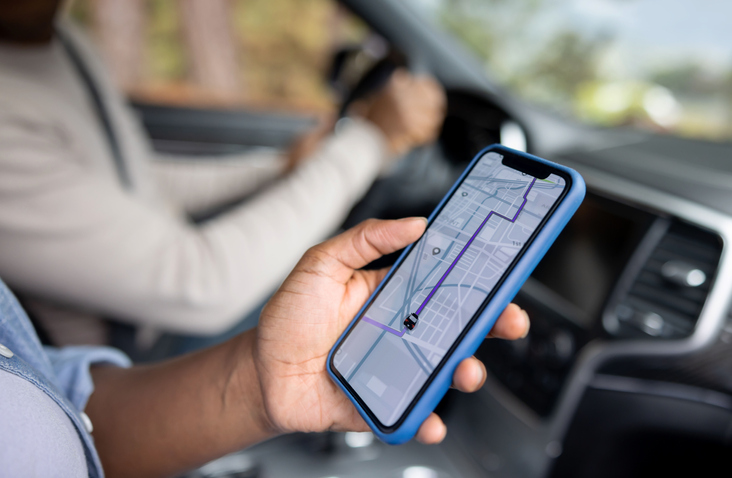 Close-up on an African American couple using the GPS on a cell phone while driving a car - lifestyle concept.