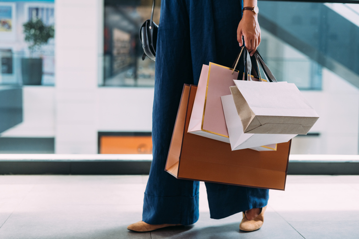 An unrecognizable Caucasian female standing at the shopping mall with paper bags